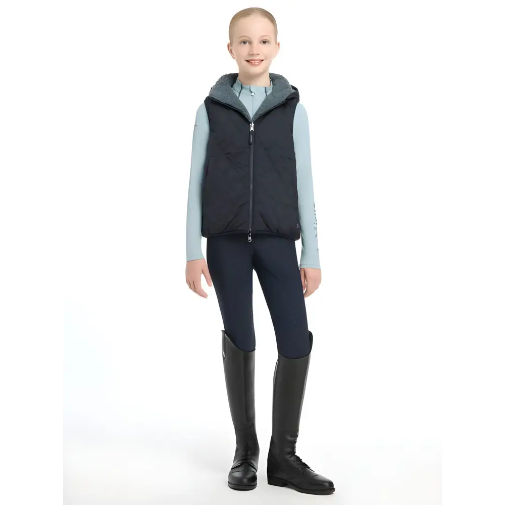 Person in Lemieux Young Rider Eloise Reversible Winter Gilet Navy with tall boots