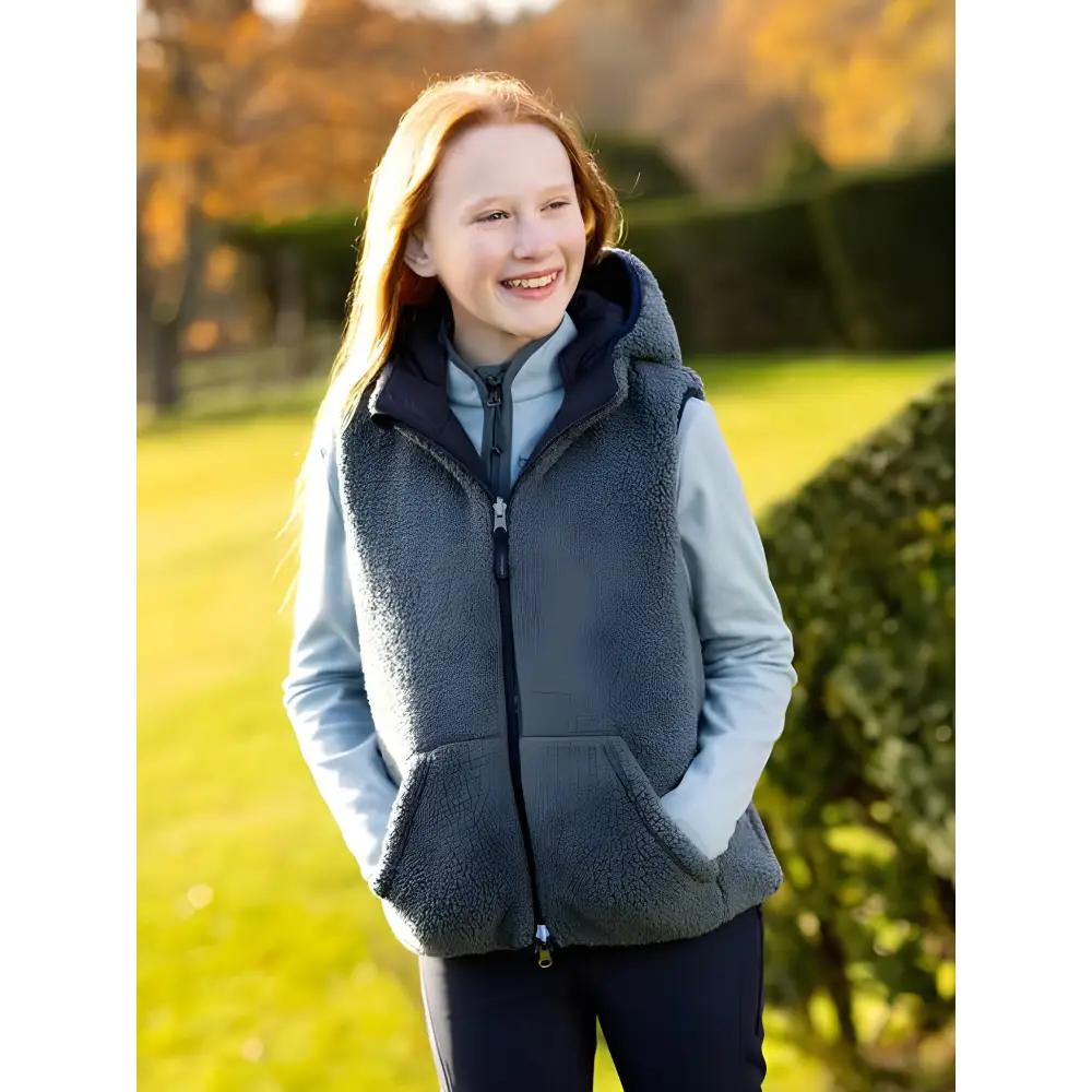 Smiling young woman in Lemieux Young Rider Eloise Reversible Winter Gilet Navy