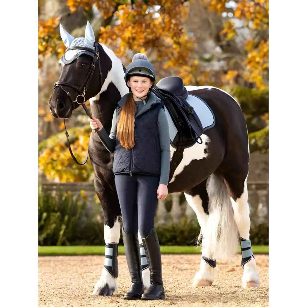 Horse with black and white coloring beside rider in Lemieux Young Rider Eloise Gilet