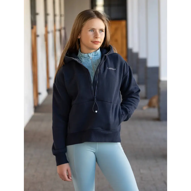 Woman in Navy Young Rider Hettie Half Zip Hoodie over Light Blue Outfit