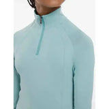 A light blue lemieux young rider hope lightweight base layer with long sleeves and a high collar zipper
