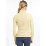 A pale yellow quilted lemieux young rider josephine jacket mimosa with long sleeves and a high collar