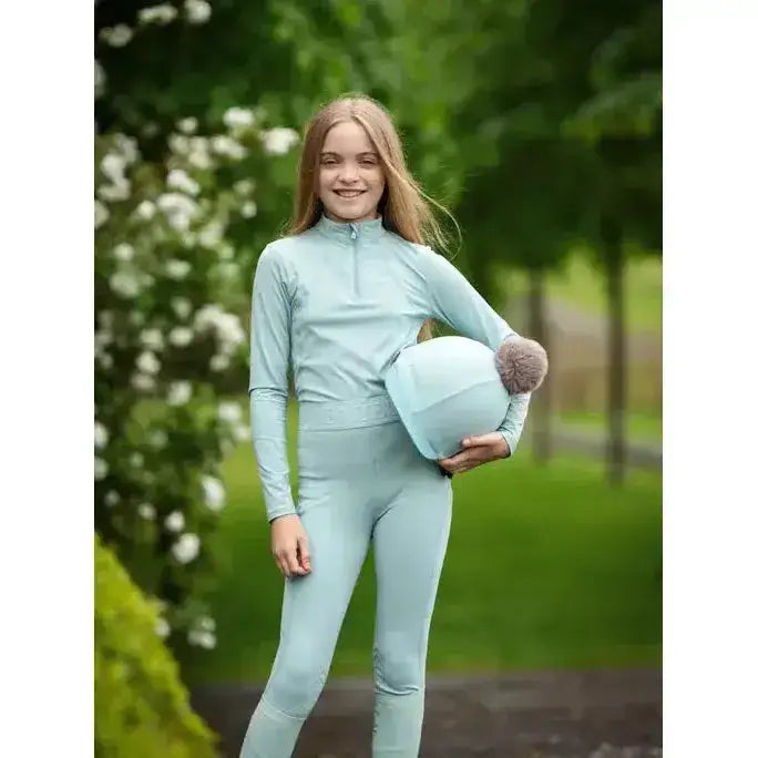 Light blue long sleeved high neck athletic top with quarter zip for lemieux young rider lizzie mesh legging aqua outfit
