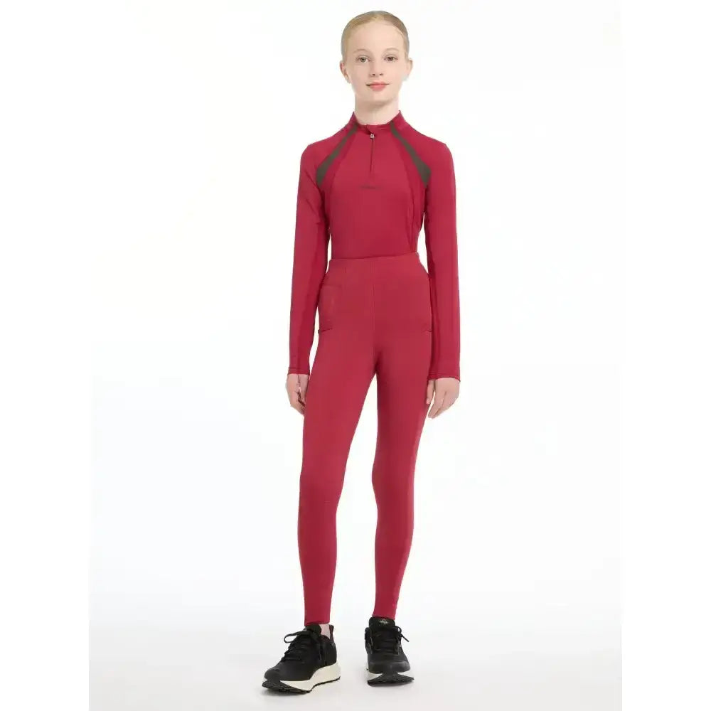 Red long-sleeved athletic jumpsuit with dark gray panels from lemieux young rider orla pull ons for active kids