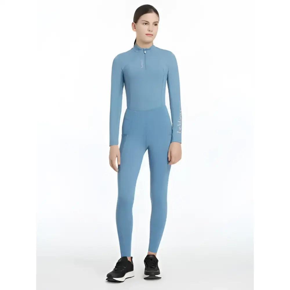 A sleek light blue lemieux young rider orla pull ons ice jumpsuit with long sleeves high collar and zipper detail