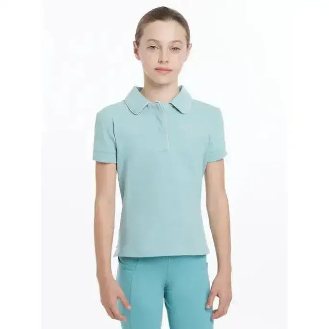 A light blue lemieux young rider polo shirt with short sleeves classic collar and subtle ribbed texture