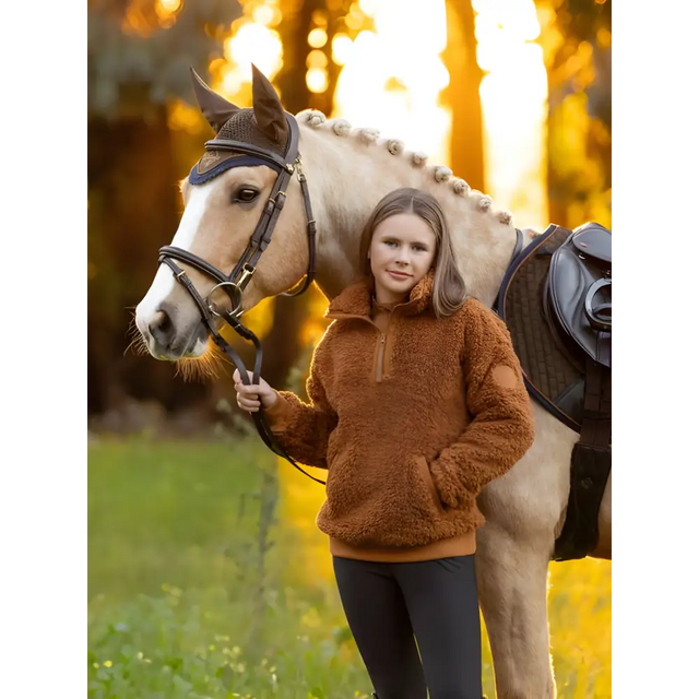 White horse with saddle beside person in Tia Teddy Fleece Ginger cozy sweater