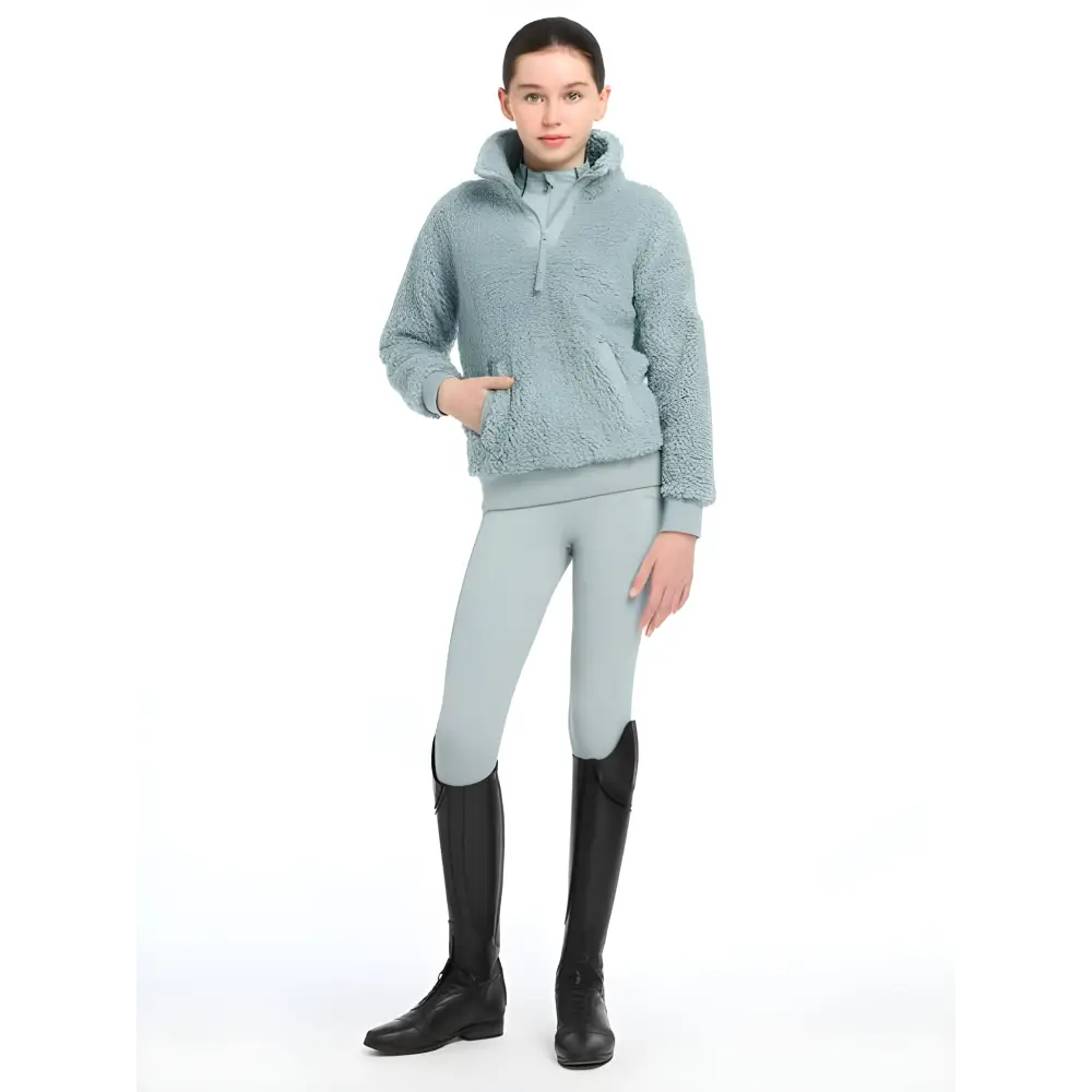 Woman in Lemieux Tia Teddy Fleece Glacier, mint green fleece jacket and riding boots