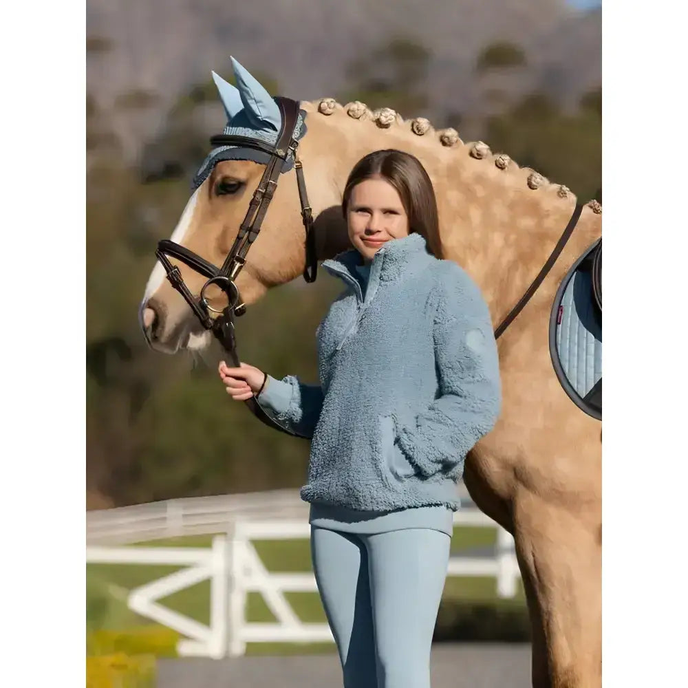 A soft light blue lemieux young rider tia teddy fleece jacket with a half-zip collar and cozy texture
