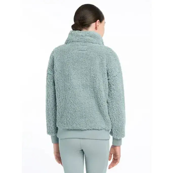 A soft light teal lemieux young rider tia teddy fleece jacket with high collar and ribbed cuffs