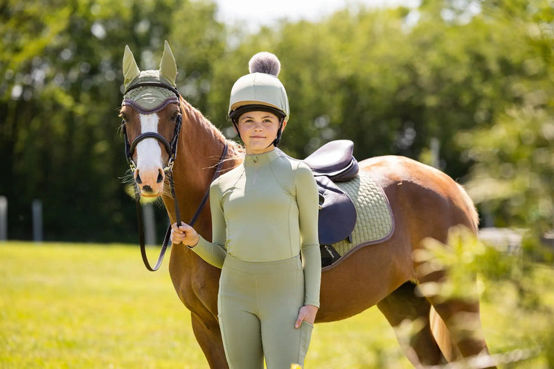 A light green, form-fitting equestrian outfit with long sleeves and matching leggings.
