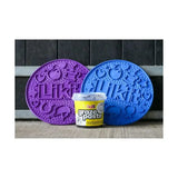 Purple and blue silicone pet training mats with embossed designs next to a yellow tub of likit graze paste tasty licking paste