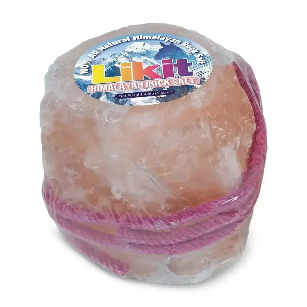 A round translucent pink himalayan rock salt lick wrapped in plastic with a purple ribbon and likit label on top