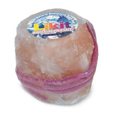 A round translucent pink himalayan rock salt lick wrapped in plastic with a purple ribbon and likit label on top