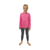 A young girl wearing a bright pink little rider base layer with subtle panels and dark star-patterned leggings in riding apparel