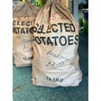 Brown paper sack of locally grown marfona potatoes labeled selected potatoes marisota priced at £8.50 for 12.5kg