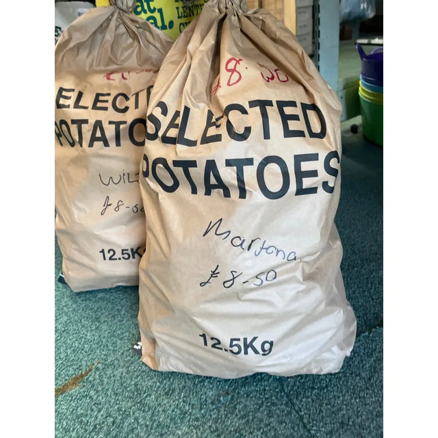 Brown paper sack of locally grown marfona potatoes labeled selected potatoes marisota priced at £8.50 for 12.5kg