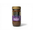 A glass jar of miles tea freeze dried instant decaf coffee with a purple label and gold lid