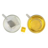 A yellow miles tea lemon envelope teabag with black text and loose dark tea inside a clear plastic pouch with lemon verbena