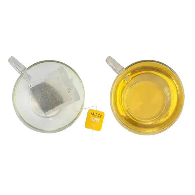 A yellow miles tea lemon envelope teabag with black text and loose dark tea inside a clear plastic pouch featuring lemon verbena