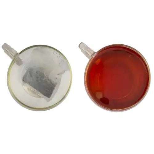 Two clear glass teacups showing miles west country original teabags with white tea bag and amber english breakfast tea