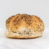 A golden brown mixed seed cob round loaf with a soft fluffy interior and slightly crispy crust
