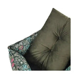 Olive green tufted velvet cushion resting against patterned armrest of morris & co blackthorn print square bed