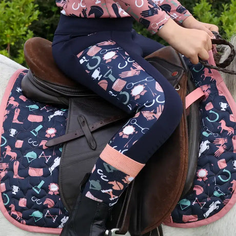 Navy blue equestrian leggings with a playful pattern of pink, white, and teal horse gear icons.