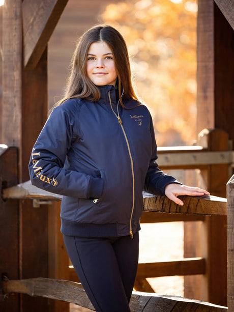Navy blue padded jacket with gold zipper and embroidered branding on the chest and sleeve