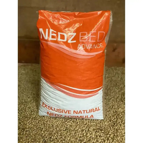 Orange and white plastic bag of nedz bed advance straw pellet bedding with exclusive natural nedz formula printed on it