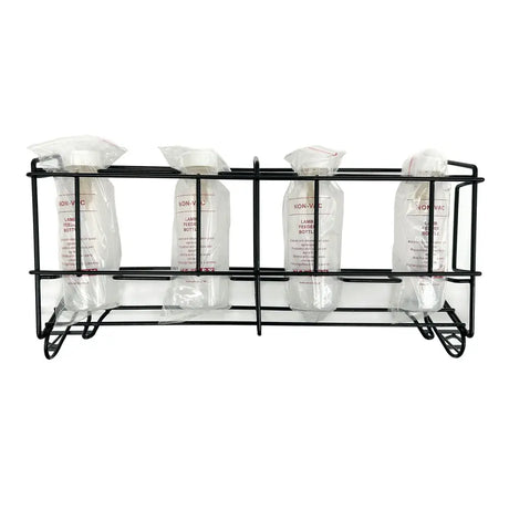 Black metal rack holding four clear plastic lamb feeder bottles sealed in bags with white caps nettex agri non-vac system