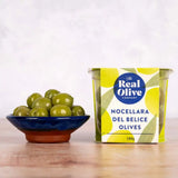A vibrant yellow and green tin of nocellara del belice stuffed green olives from the real olive company 180g