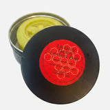Black metal tin with pale yellow north devon honey cream bar made of beeswax scented with lavender and frankincense