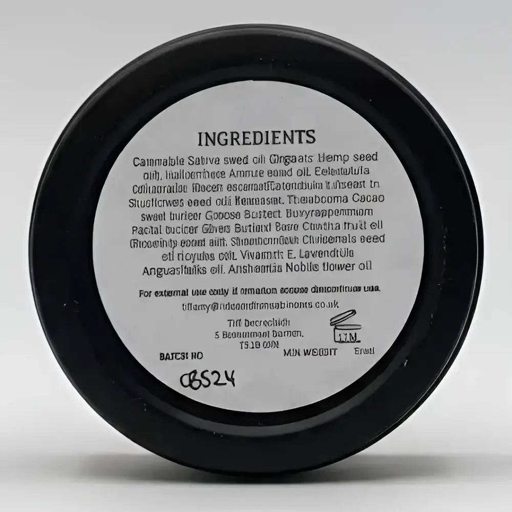 Black circular container showing back label with ingredients for north devon honey luxury beeswax sos bee balm skin care