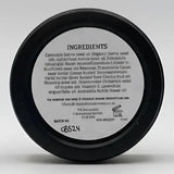 Black circular container showing back label with ingredients for north devon honey luxury beeswax sos bee balm skin care