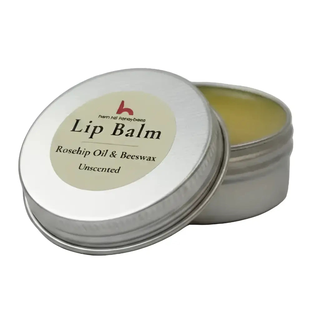 Silver tin with beige label showing ingredients for north devon honey luxury beeswax lip balm with rosehip oil