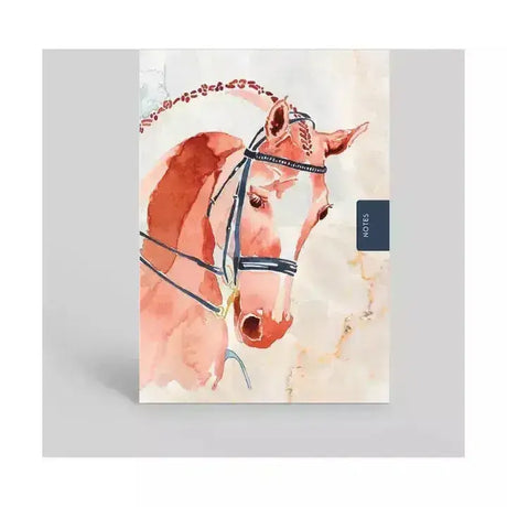 A pocket sized notebook featuring a peach competition horse with black bridle and decorative braiding on the cover
