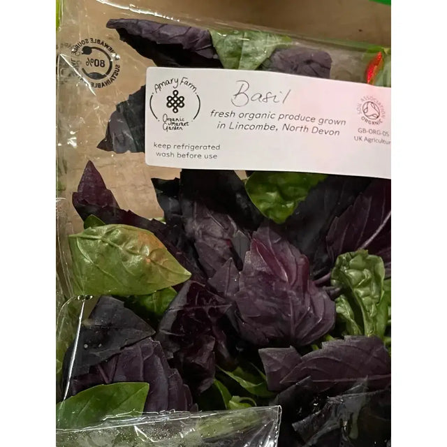 A package of organic basil with mixed purple and green leaves in a clear bag from an organically certified farm