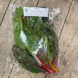 A fresh package of hand grown organic chard with vibrant green leaves and colorful red pink and orange stems