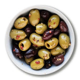 A bowl of organic chilli cumin and garlic pitted olives with green olives and red pepper flakes for a spicy kick