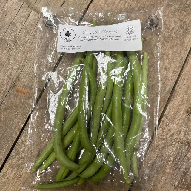 A clear plastic pack of fresh green organic french beans from a farm in north devon labeled organic french beans