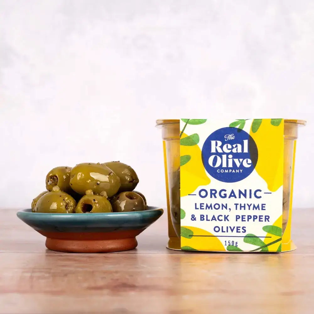 A vibrant yellow and green container of organic lemon thyme and black pepper pitted green olives from the real olive company