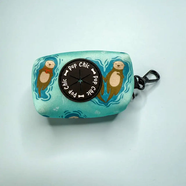 Turquoise fabric otterly lovely poo bag holder with black button and otter design for stress-free cleanups and easy access