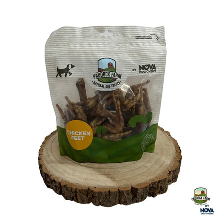 A white and green bag of paddock farm chicken feet dog treats with clear window showing natural brown chews