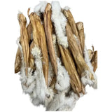 A pile of light brown paddock farm hairy dried rabbit skin treats with fluffy white fur on each end