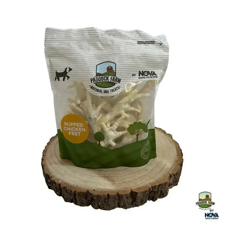 A white and green striped bag of paddock farm puffed chicken feet dog chews featuring puffed chicken feet treats