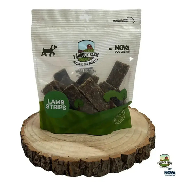 A clear resealable bag of paddock farm strips lamb treats with green and white label and dark brown chews inside