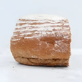A rustic artisanal pantique bread loaf with a golden brown crust lightly dusted with flour and scored lines