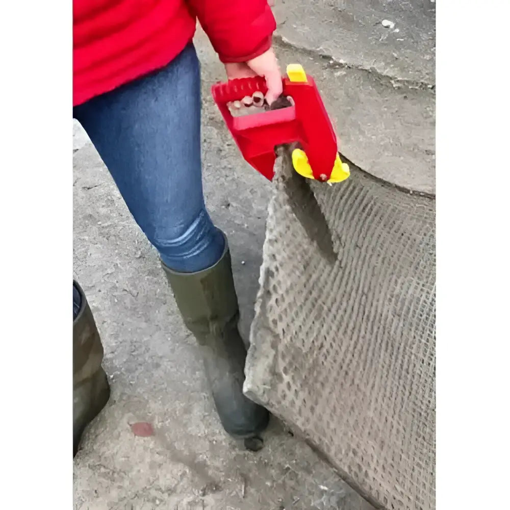 Red handheld parallax grabbit with yellow accents gripping textured gray mesh for stable accessories use