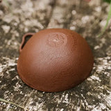 Brown textured plant-based leather keychain with embossed patent pending peckish logo and 100 percent plant based fermented text